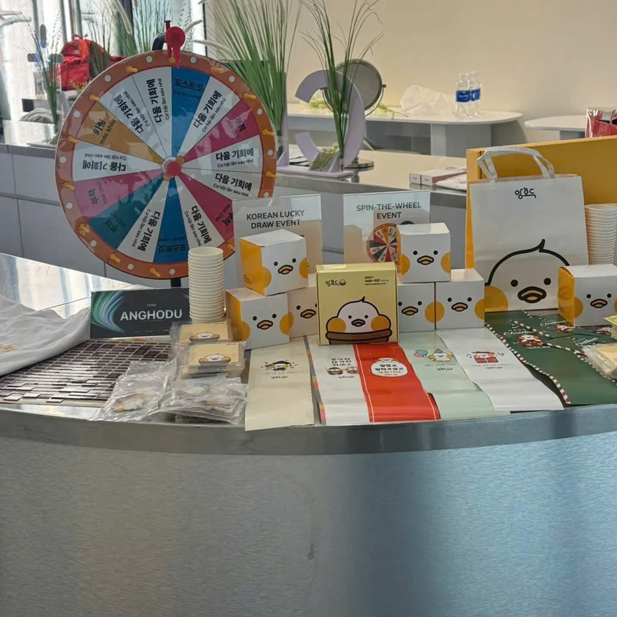 An Anghodu pop-up booth abroad: prize wheel, goods and packaging laid out on the counter