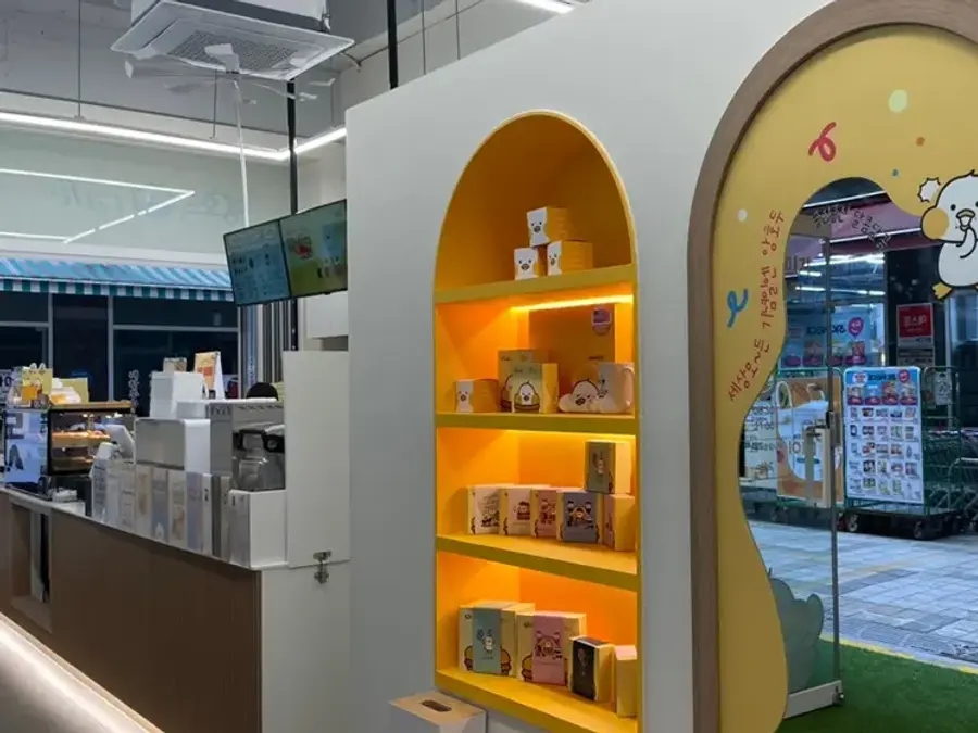 Lit shelving displaying gift boxes inside an ANGHODU store