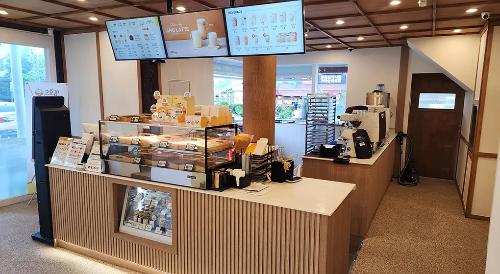 Serving counter with menu screens and display case
